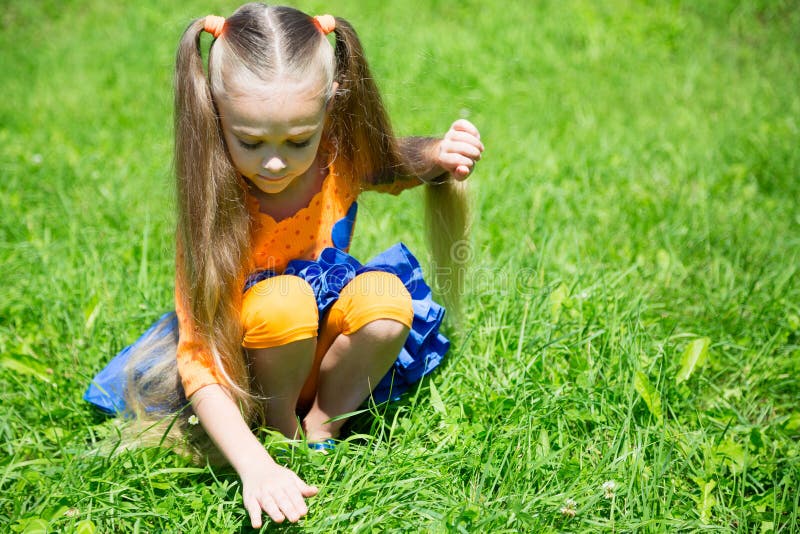 Cute little girl catches a grasshopper stock image Cute little girl catches a grasshopper stock image