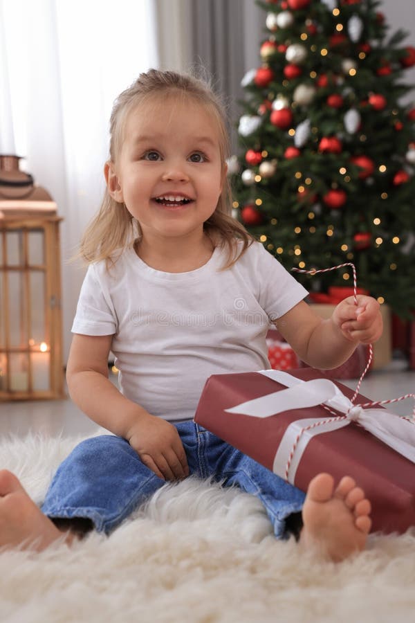 Cute Little Girl with Christmas Gift in Festively Decorated Room Stock ...