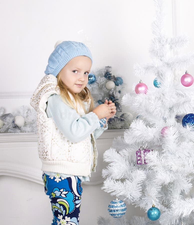 Cute little girl decorating Christmas tree