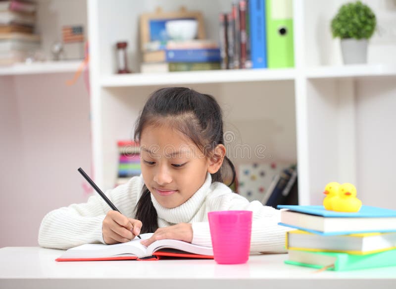 Cute little girl doing homework reading a book coloring pages writing and painting. Children paint. Kids draw. Preschooler with b royalty free stock photo Cute little girl doing homework reading a book coloring pages writing and painting. Children paint. Kids draw. Preschooler with b royalty free stock photo