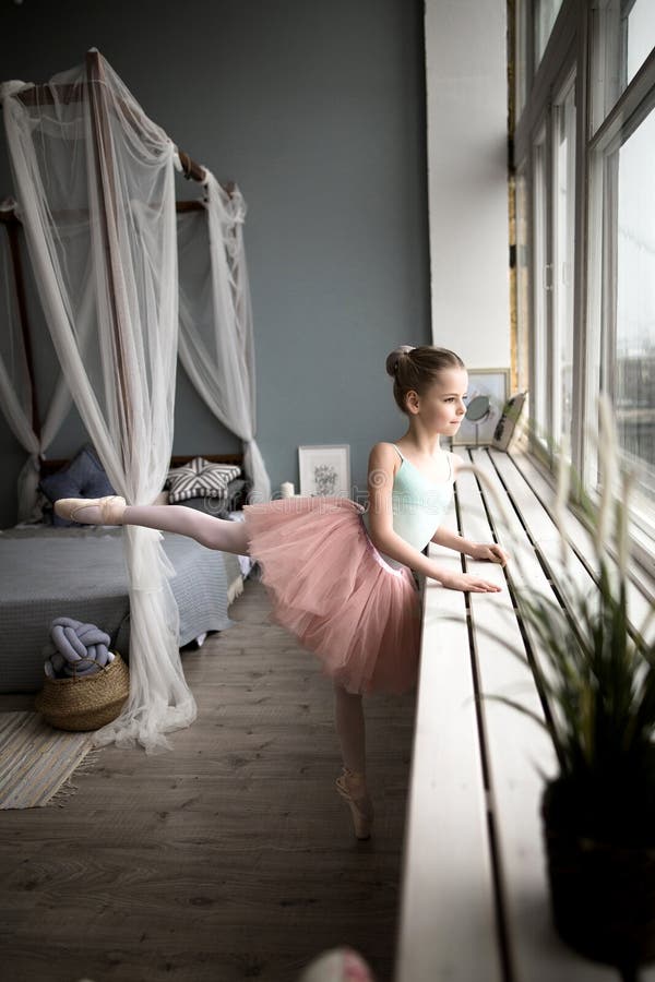 Little girl dreams of becoming a ballerina. Child in a pink tutu dancing in a kids room. royalty free stock photography Little girl dreams of becoming a ballerina. Child in a pink tutu dancing in a kids room. royalty free stock photography