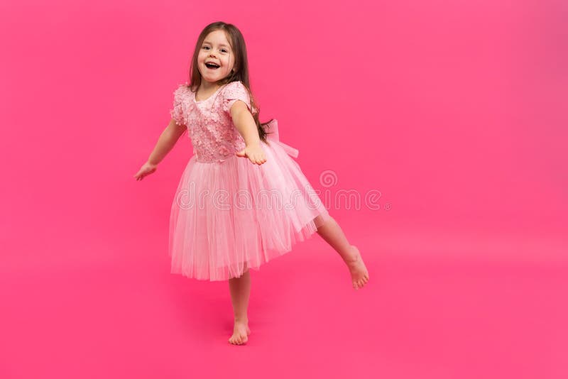 Cute little girl dreams of becoming a ballerina. Little Dancing Girl. Studio Shoot Over Pink Background stock photos Cute little girl dreams of becoming a ballerina. Little Dancing Girl. Studio Shoot Over Pink Background stock photos