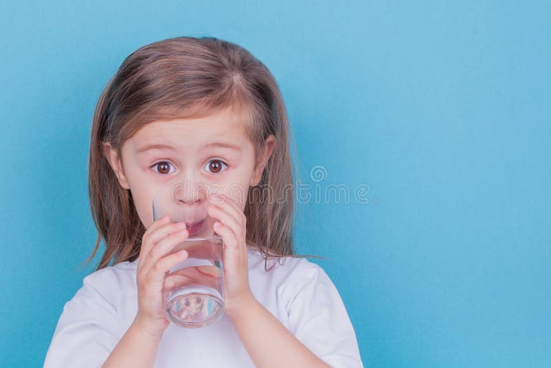 Cute little girl drinking water from glass royalty free stock photography Cute little girl drinking water from glass royalty free stock photography