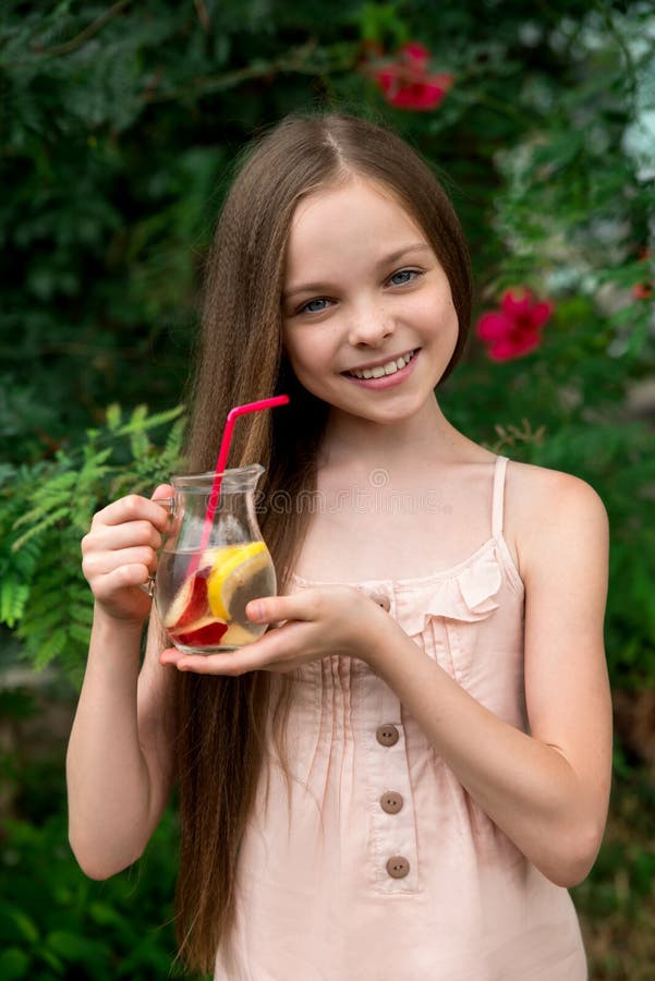 Cute little girl drinks lemonade