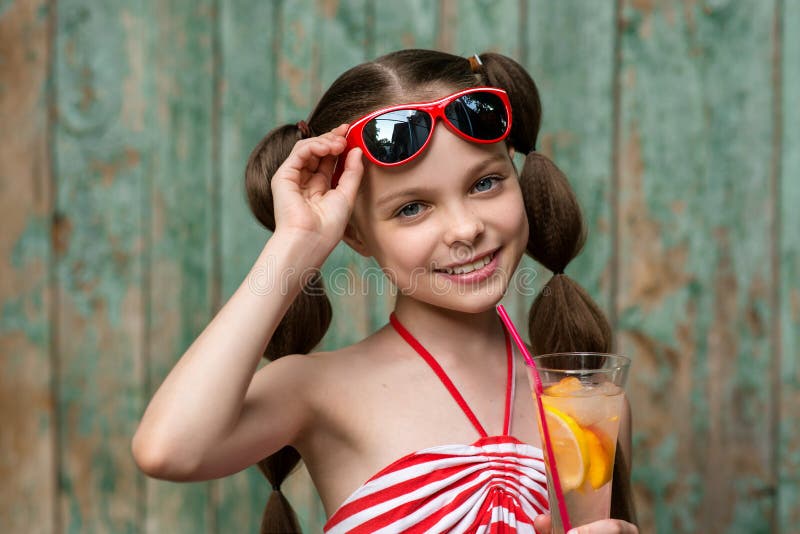 Cute little girl drinks lemonade