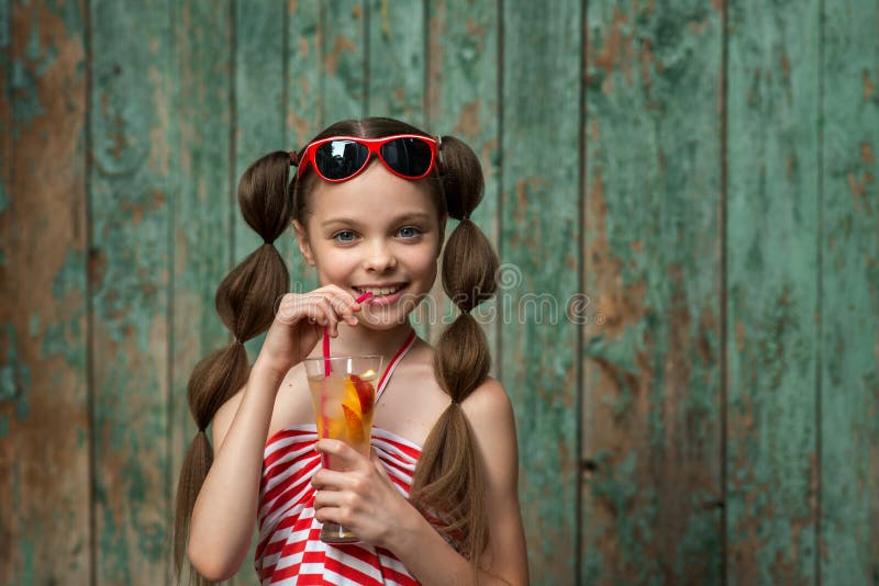 Cute little girl drinks lemonade