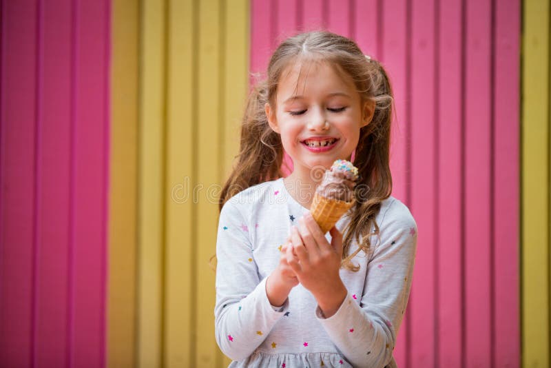 Cute little girl eating chocolate ice cream.