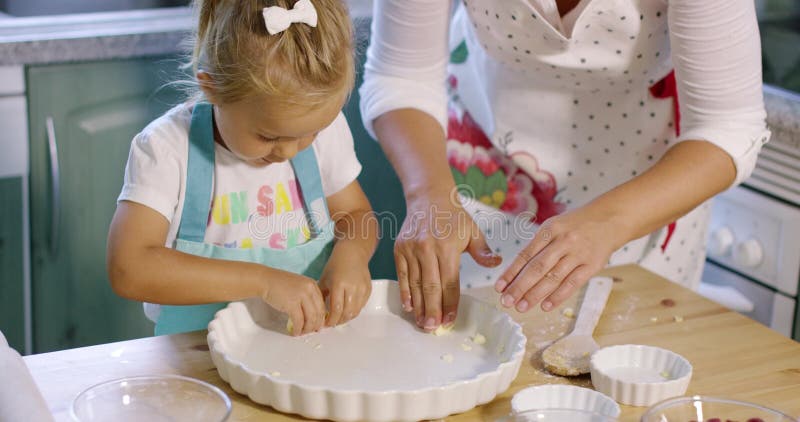 Cute little girl greasing a baking dish