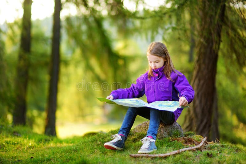 Cute little girl having fun during forest hike on beautiful autumn day in Italian Alps