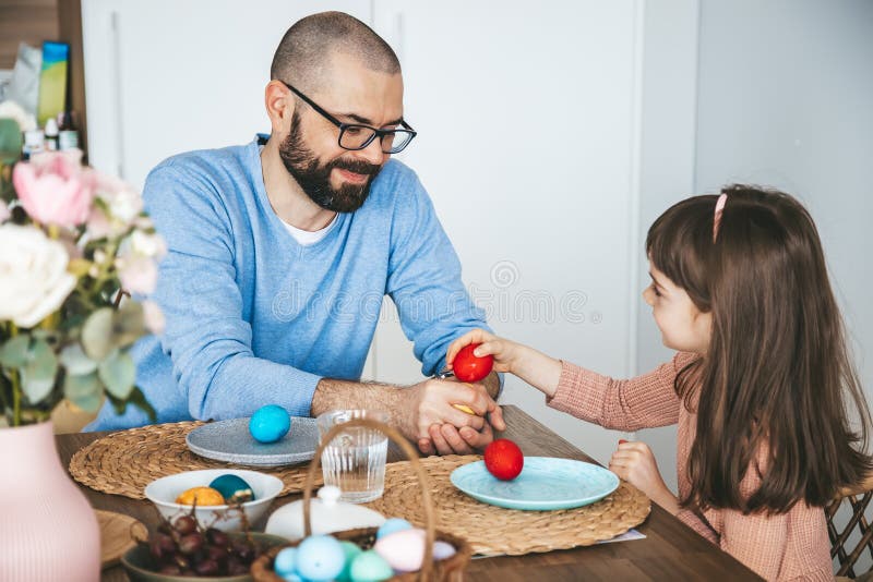 Cute Little Girl and Her Father Playing an Egg Tapping Game with Easter