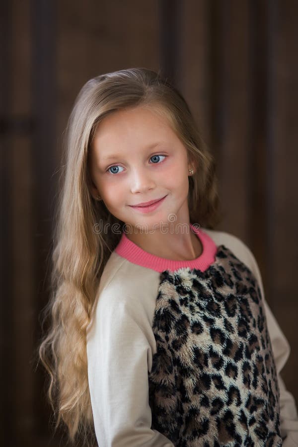 Cute Little Girl with Long Hair on a Brown Background Close-up Stock ...