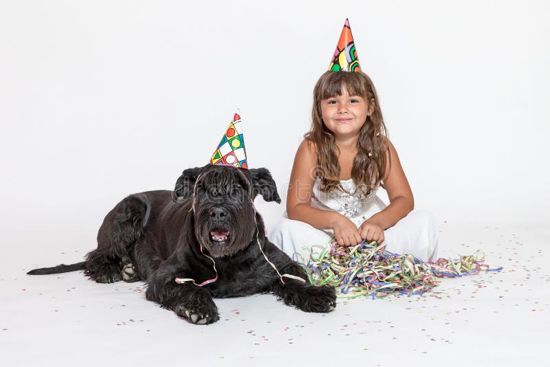 Cute little girl with lying black dog on the white