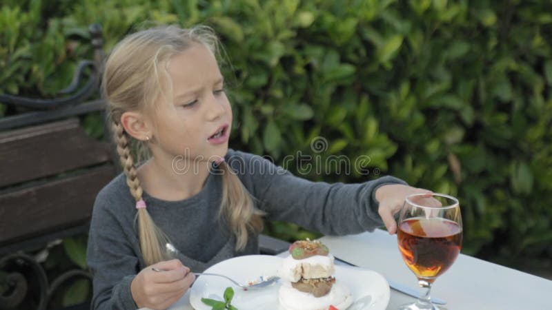 Cute little girl with pigtails eating dessert