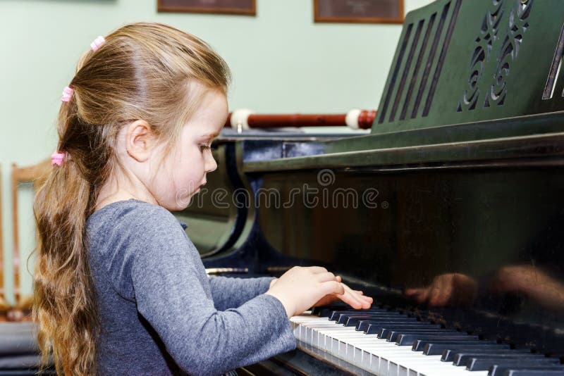 Cute little girl playing grand piano