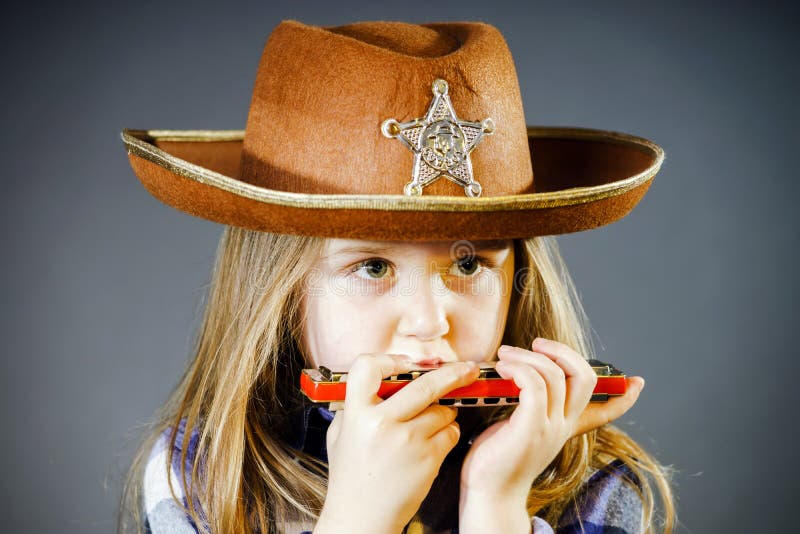 Cute little girl playing harmonica stock photos