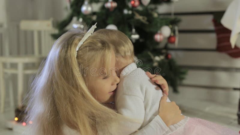 Cute little girl playing with her baby sister near