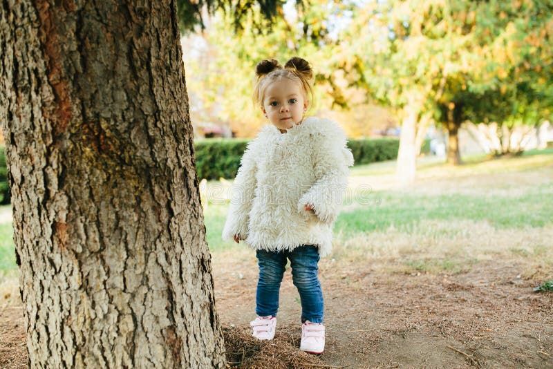 Cute little girl is playing hide and seek outdoors. Cute little girl is playing hide and seek outdoors