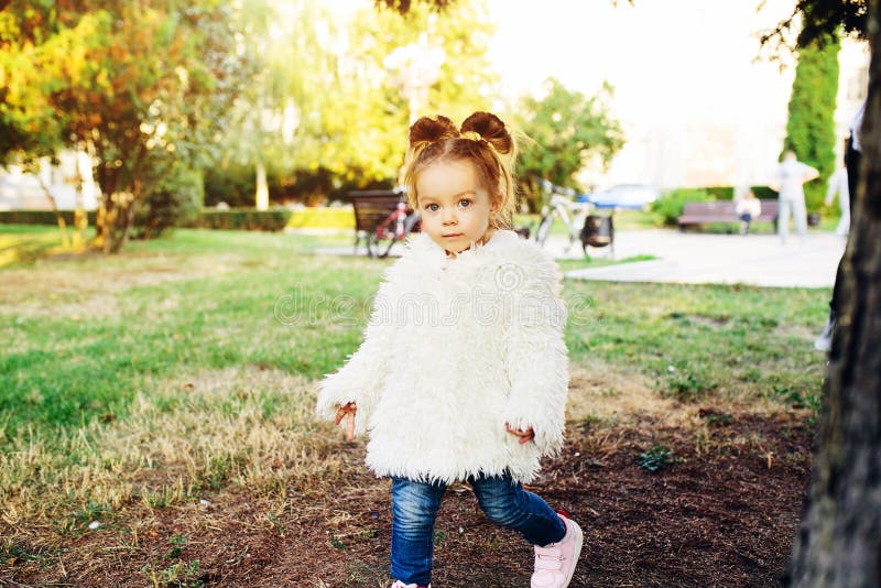 Cute little girl is playing hide and seek outdoors. Cute little girl is playing hide and seek outdoors