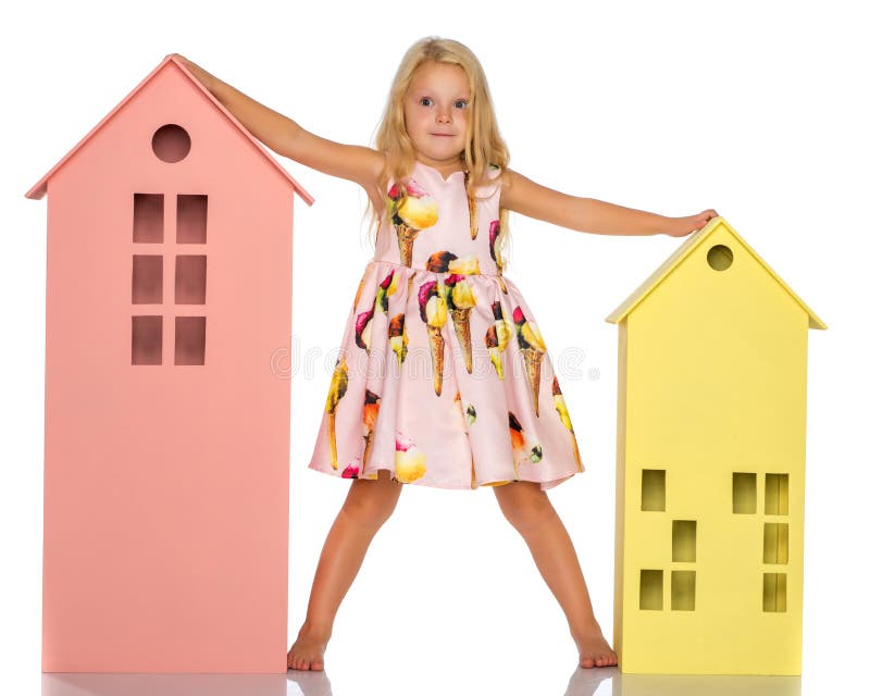 Little girl is playing with wooden houses.