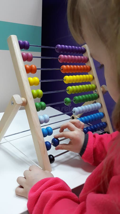 Cute little girl plays wooden abacus. Baby girl counting with help of an abacus. Smart child learning to count. stock images Cute little girl plays wooden abacus. Baby girl counting with help of an abacus. Smart child learning to count. stock images