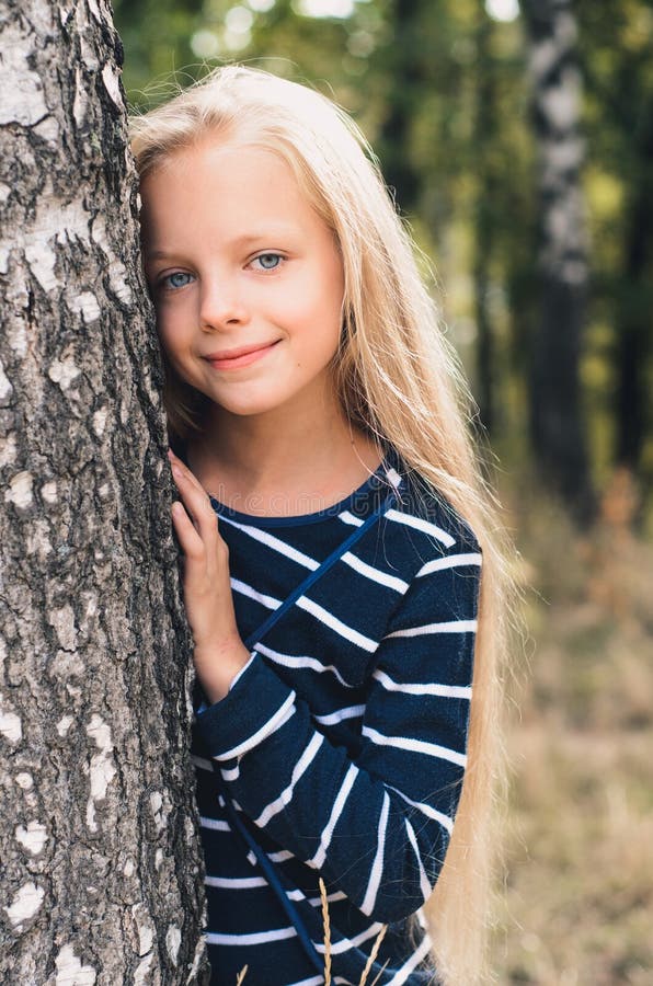 Cute Little girl portrait near tree birch.