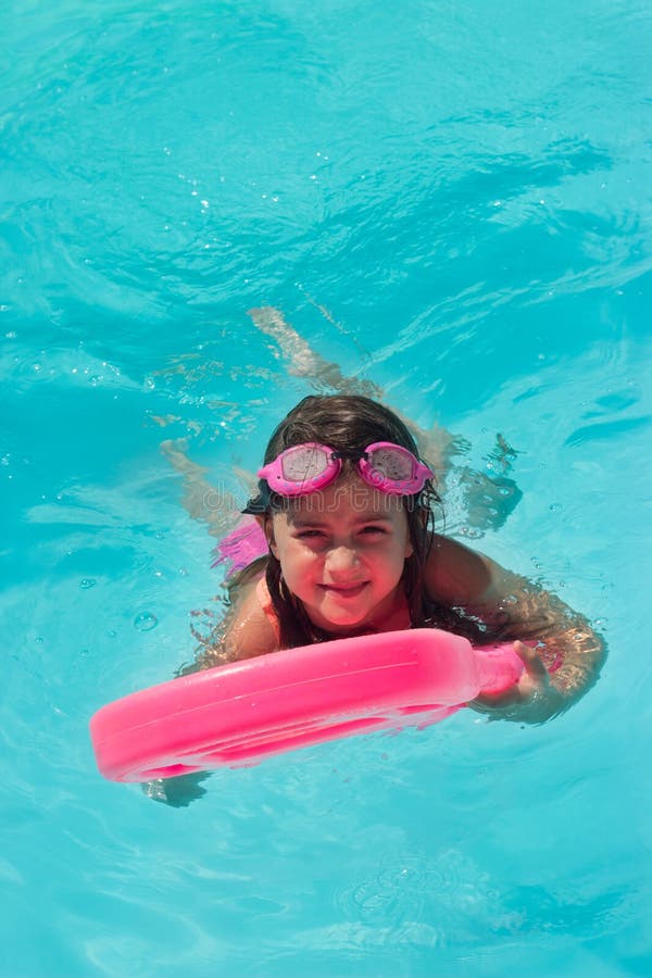 Cute Little Girl Practices Swimming on a Kick Board in the Pool Stock ...