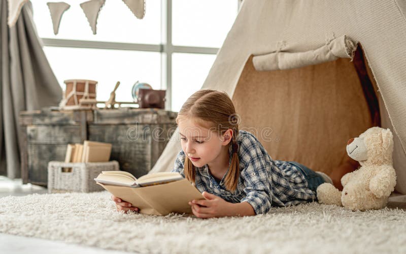 Cute little girl reading adventure book