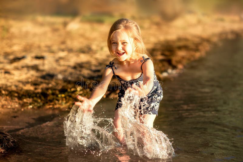 Cute Little Girl Running Along River Bank Stock Photo - Image of ...