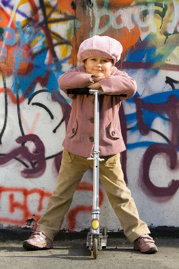 Cute little girl with scooter near graffiti wall royalty free stock photo Cute little girl with scooter near graffiti wall royalty free stock photo