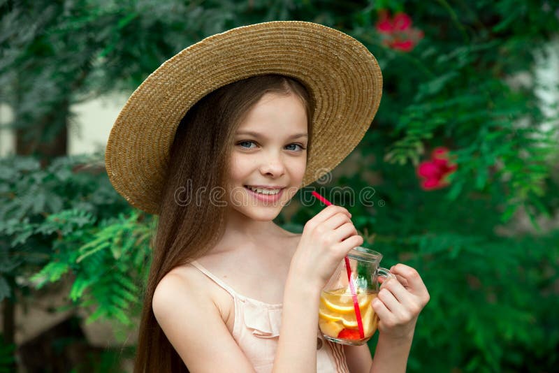 Cute little girl drinks lemonade