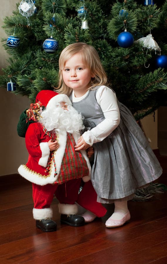 Cute little girl with toy Santa Claus