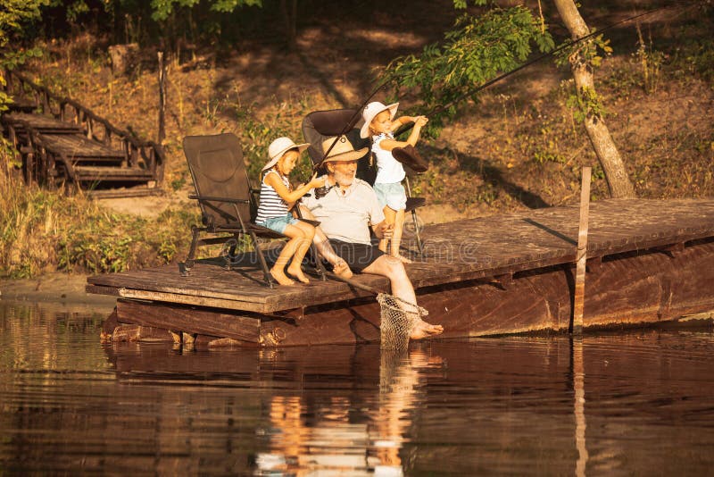 Cute little girls and their granddad are on fishing at the lake or river royalty free stock images Cute little girls and their granddad are on fishing at the lake or river royalty free stock images