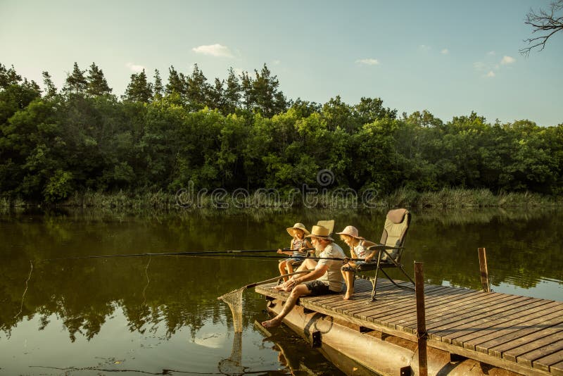 Cute little girls and their granddad are on fishing at the lake or river royalty free stock photo Cute little girls and their granddad are on fishing at the lake or river royalty free stock photo