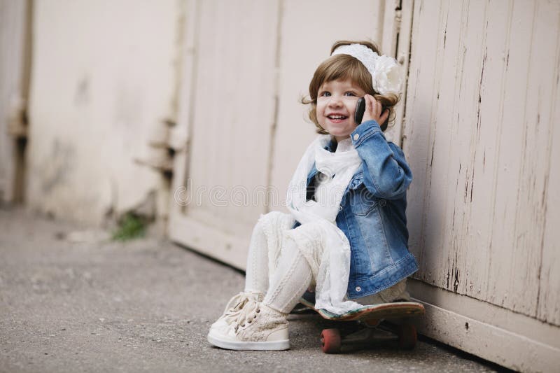 Cute little hipster girl with skateboard