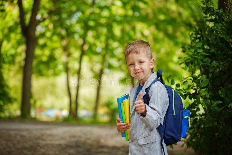 Cute little kid boy with books and backpack on green nature bac royalty free stock image Cute little kid boy with books and backpack on green nature bac royalty free stock image