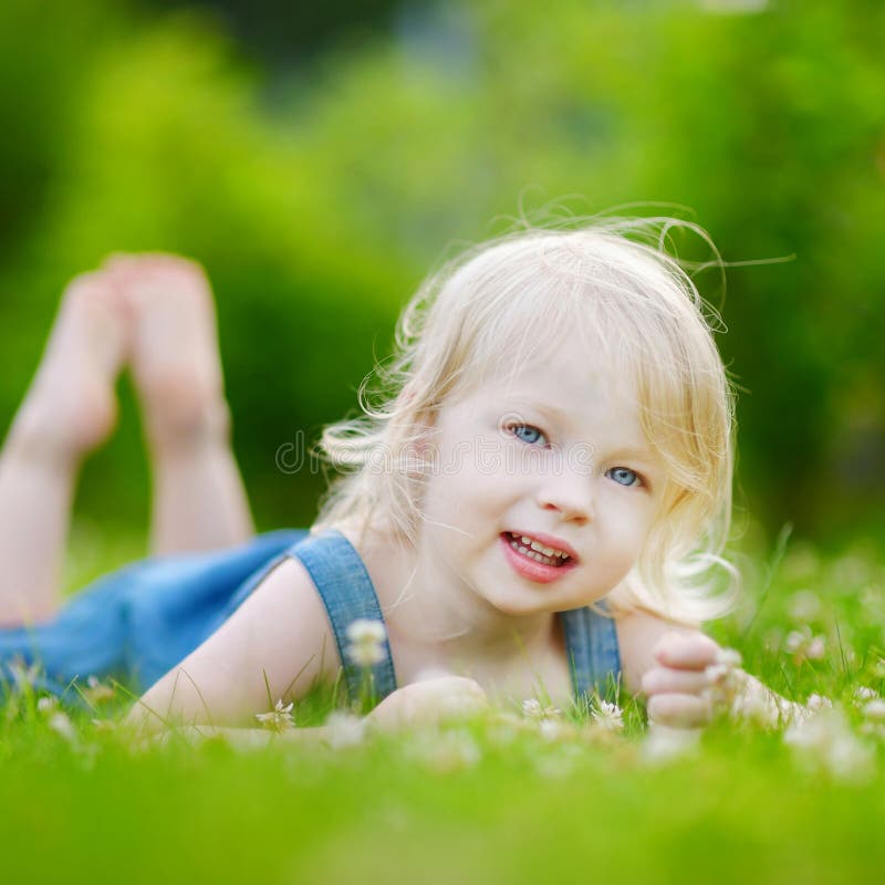 Cute little toddler girl laying in the grass