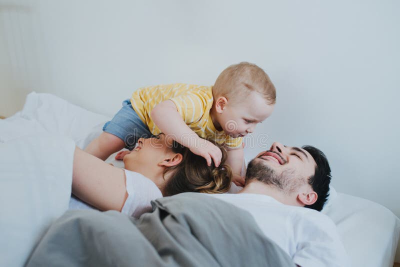 Cute little son trying to wake up his parents.