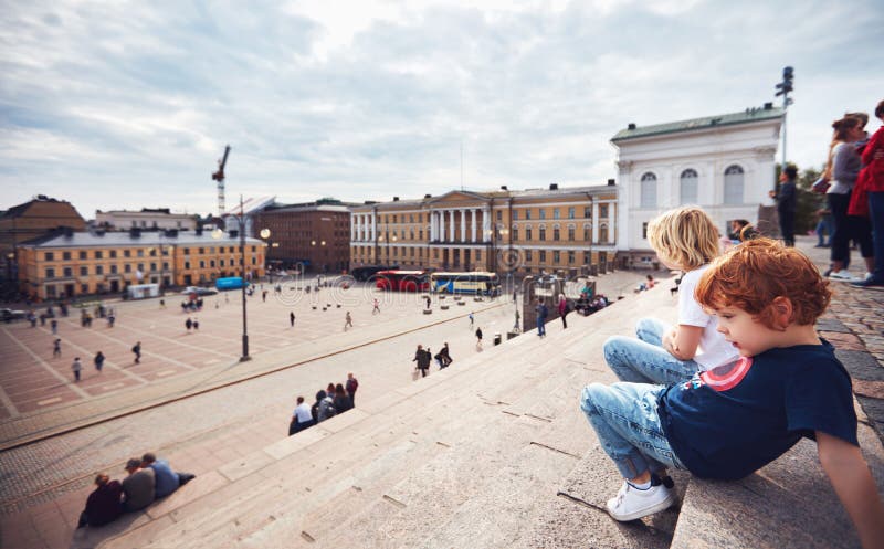 Cute little tourists are relaxing on the step stairs of Helsinki Cathedral, on the Senate Square. Helsinki, Finland stock photo Cute little tourists are relaxing on the step stairs of Helsinki Cathedral, on the Senate Square. Helsinki, Finland stock photo