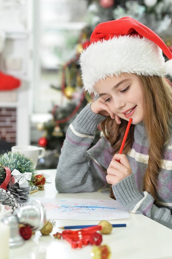 Cute long-haired girl writing letter for Santa