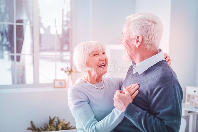 Cute loving couple of pensioners feeling cheerful dancing at home stock photos Cute loving couple of pensioners feeling cheerful dancing at home stock photos