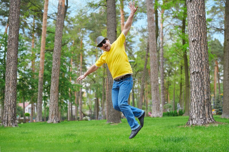 Cute man jumping in the park on sunny day
