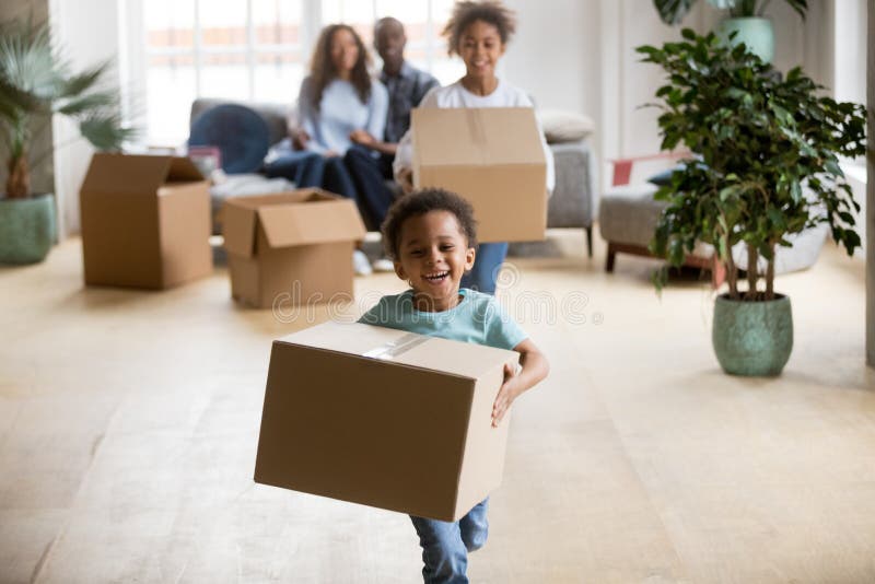 Cute happy mixed race children enjoying moving day running carrying holding boxes, excited african american kids laughing playing in new home having fun unpacking, black family relocation concept. Cute happy mixed race children enjoying moving day running carrying holding boxes, excited african american kids laughing playing in new home having fun unpacking, black family relocation concept
