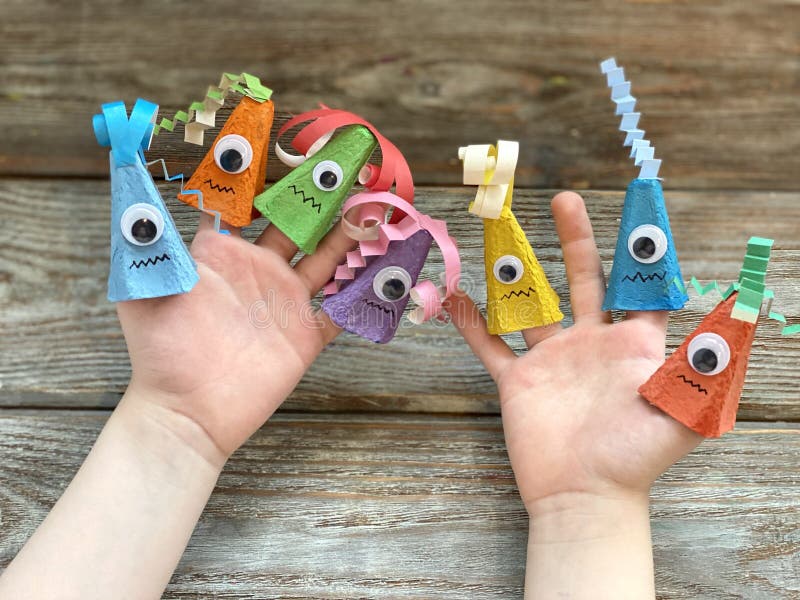 Cute monsters on children& x27;s hand, kids DIY from recycling egg box.
