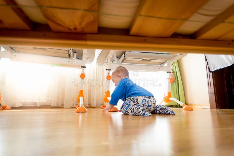 Cute 9 Months Old Baby Boy Crawling Under the Bed Stock Photo Image