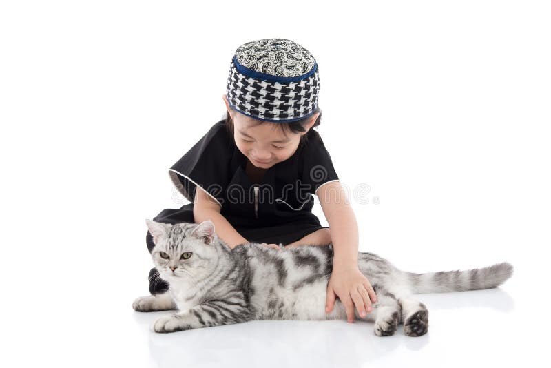 Cute muslim child playing with tabby cat
