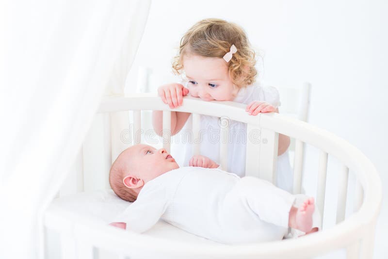 Cute newborn baby boy watching his toddler sister standing at hi royalty free stock photos Cute newborn baby boy watching his toddler sister standing at hi royalty free stock photos