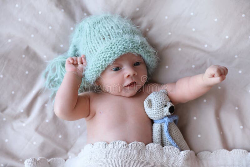Newborn Baby in Warm Hat with Toy Lying on Bed, Top View Stock Image ...