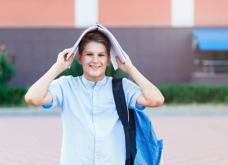 Cute, Nice, Young 11 Years Old Boy in Blue Shirt Stands with Workbooks ...