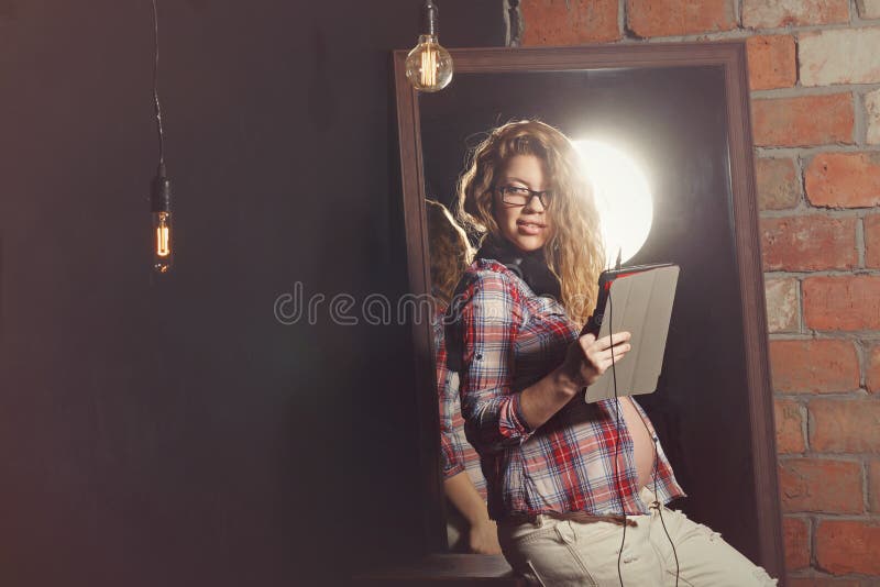 Cute pregnant girl with tablet pc