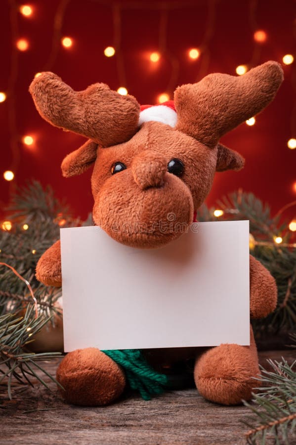 Cute Reindeer Toy in Santa Hat Holding a White Writeable Card, Sheet of  Paper in a Christmas Scenario. Stock Photo - Image of seasonal, happy:  196992954